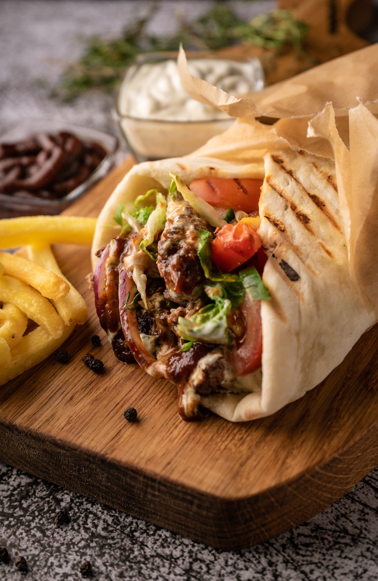 doner kebab, a shawarma in a pit of fresh vegetables and meat. with large spices. restaurant serving. on a dark background. for menus and ads